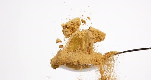 Ginger Slices and Powder Falling onto Spoon