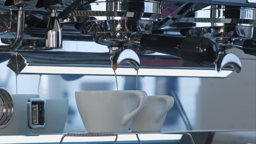 Coffee Brewing from Espresso Machine into White Cups