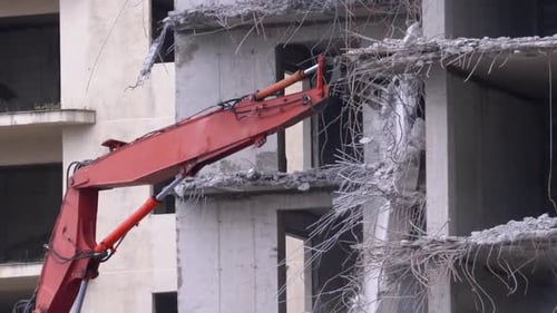 Crane Demolishing Tall Concrete Building