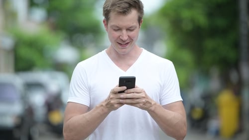 Young Adult Man Using Mobile Phone Outdoors