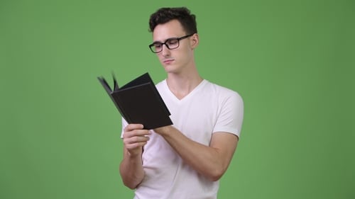 Young Adult Reading Book Against Green Screen