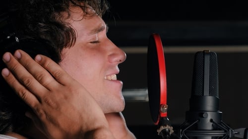 Young Handsome Singer Man Emotionally Writing Song in the Studio