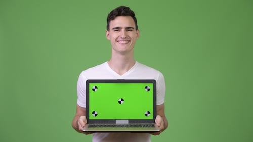 Young Adult Holds Laptop with Chroma Key Screen
