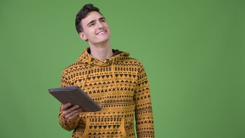 Young Man Using Tablet in Front of Green Screen