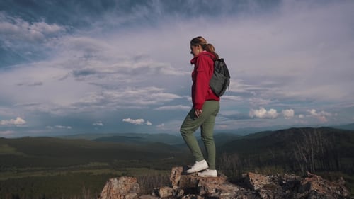 Girl Traveler Coming To the Edge of the Cliff in the Mountains and Enjoying the Beautiful View