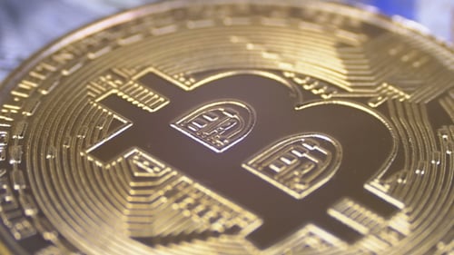 Gold Bitcoin Coin Cryptocurrency, BTC Rotate on Background with US Dollars