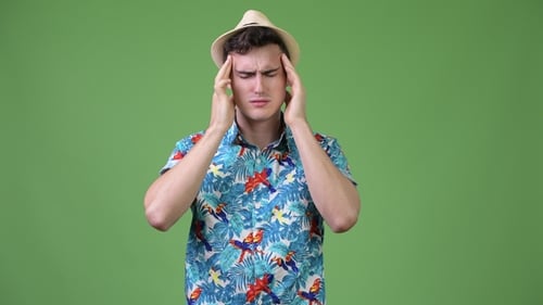 Man With Headache Rubbing Temples Against Green Screen