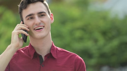 Young Man Talking on Mobile Phone Outside