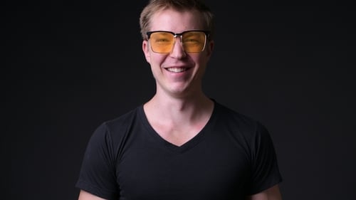 Junger gutaussehender Mann vor schwarzem Hintergrund