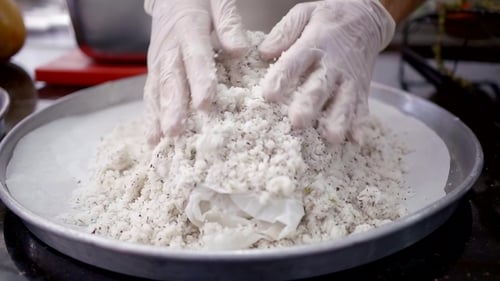 El chef está cubriendo un trozo de carne o pescado con mucha sal con especias, lo que hace que la cáscara sea para hornear