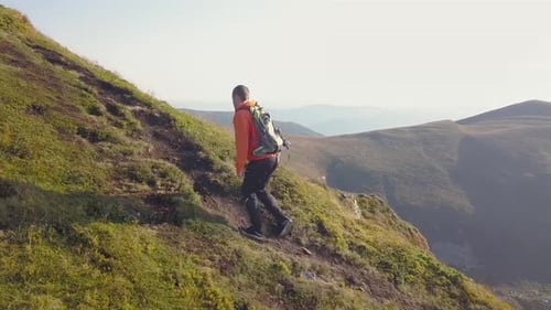 Tourist Hiker with a Backpack Walking on Mountain Path in Carpathian Mountains