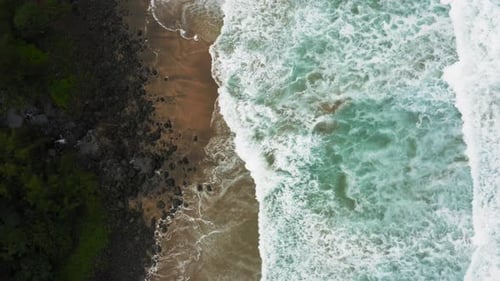 Vue aérienne sur une belle vague de l'océan limpide qui roule sur une plage de sable sauvage. Sondage Topdown
.