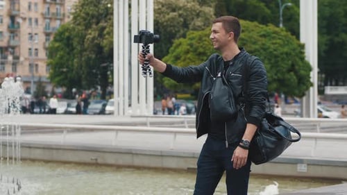 Young Male Blogger Broadcasting Video Blog From a City Street