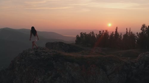 Young Happy Woman Standing on the Edge of a Cliff