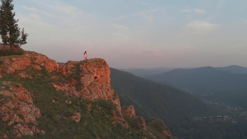 Young Happy Woman Standing on the Edge of a Cliff