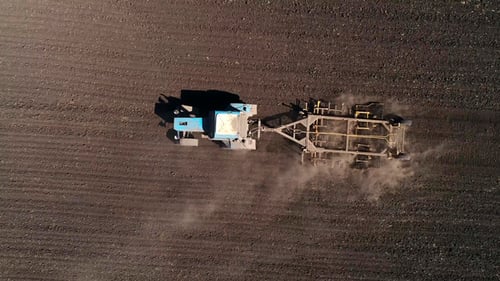 Aerial View of Agricultural Tractor Cultivating Field. Tractor At Work.