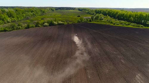 Aerial View of Agricultural Tractor Cultivating Field. Tractor At Work.