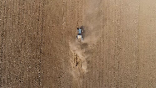 Aerial View of Agricultural Tractor Cultivating Field. Tractor At Work.