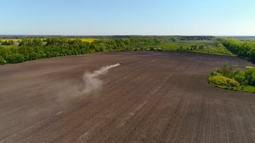 Aerial View of Agricultural Tractor Cultivating Field.
