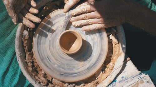 Mains du maître potier et vase d'argile sur le tour de potier