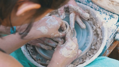 Hands Shaping Clay on Pottery Wheel Close Up