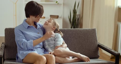 Woman Hugging a Child on a Couch