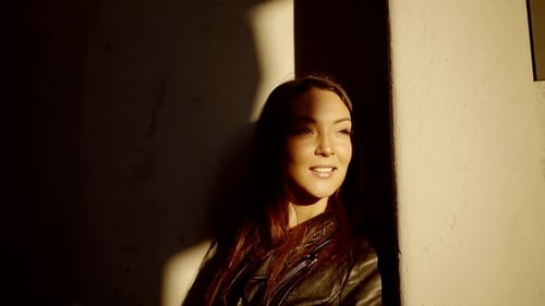 Portrait of Happy Young Girls on a Sunny Spring Evening, Standing at the Wall and Smiling Looking To