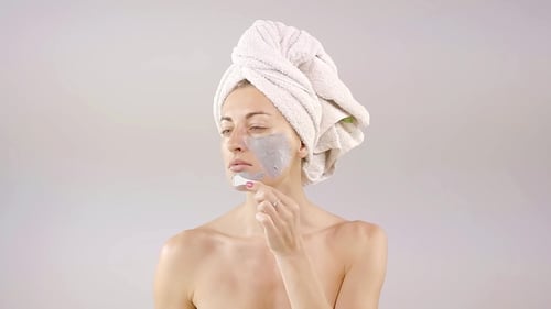 Young European Woman Applies Scrub on Her Face