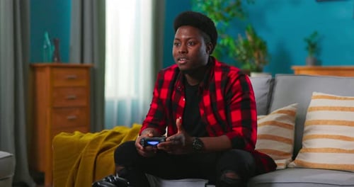 Young Adult Playing Video Game on Couch