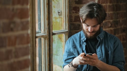 Man Texts Message By Window