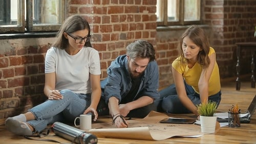 Team Discussing Project on Floor in Urban Workplace