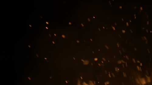 Burning Ash Rise From Large Fire in Black Background