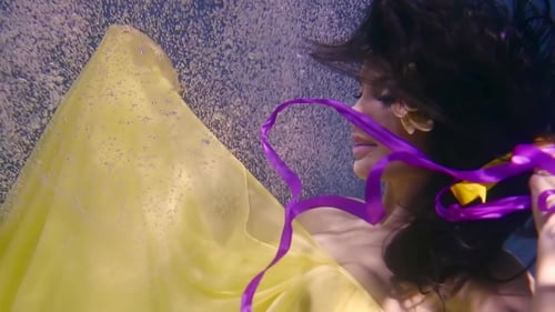 Femme élégante dans une robe jaune avec des rubans dans ses mains flotte sous l'eau comme un conte de fées