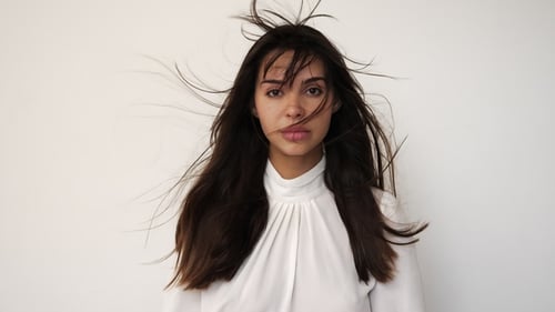 Young Woman with Flowing Hair Posing Indoors