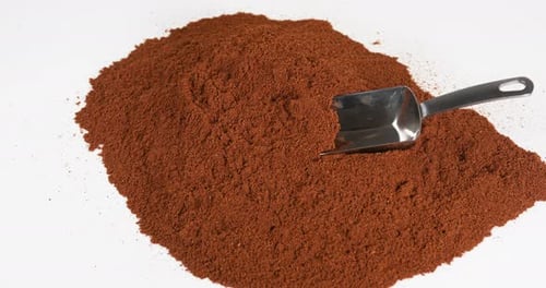 Metal Scoop Digging into a Pile of Powder