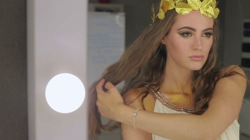 Woman Styles Hair with Golden Crown Indoors