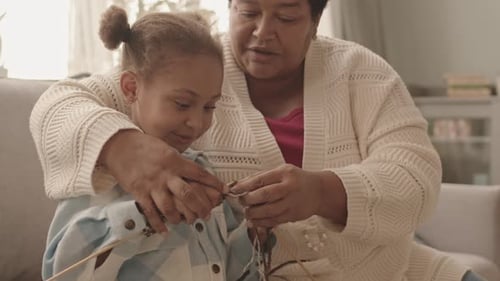 Mature Woman Helping Girl Knit