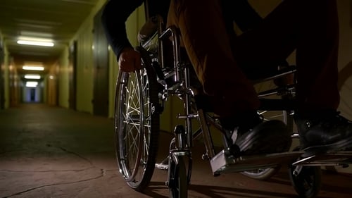 Shot of a Wheelchair, a Man Twists the Wheels in Order To Move Around the Hospital Hall