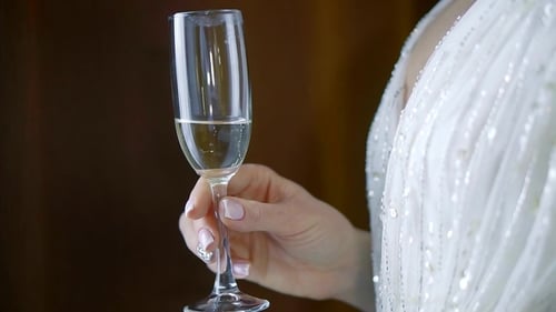 Woman Drinks Champagne in Decorative White Dress
