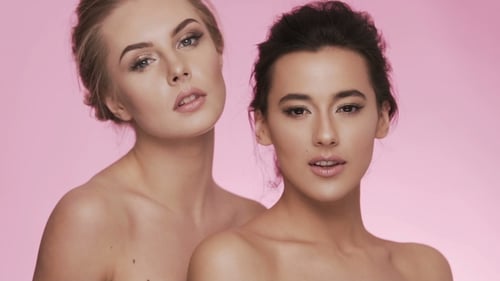 Two Women Posing in Studio with Pink Background