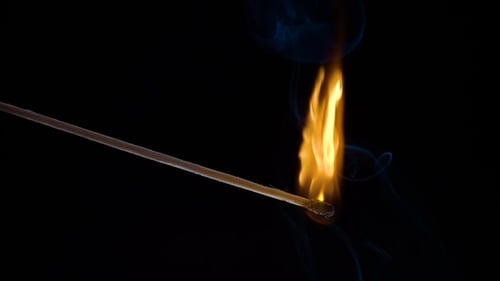 Matchstick Ignited with Vivid Flame on Black Background