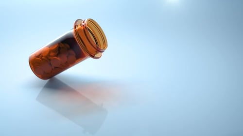Medical Pills Falling Out of Orange Plastic Container