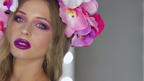 Femme avec des fleurs et un maquillage lumineux
