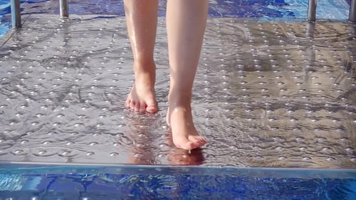 Schuss von den Füßen des Kindes, das das saubere Wasser des Pools betritt
