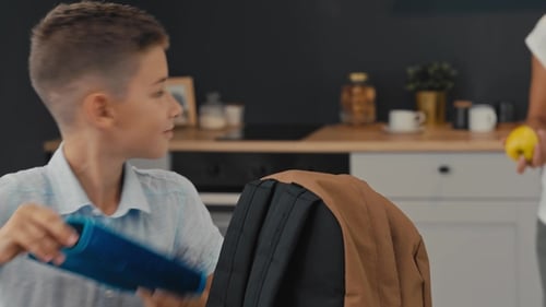 Mom and Son Prepare a Backpack for the First School Day