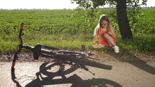 Teenage Girl Sitting on Road After Bicycle Crash