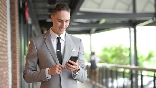 Man in Suit Using Smartphone Outdoors