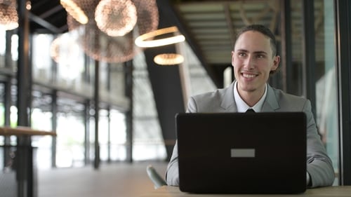 Businessman Using Laptop Computer Outdoors In Coffee Shop