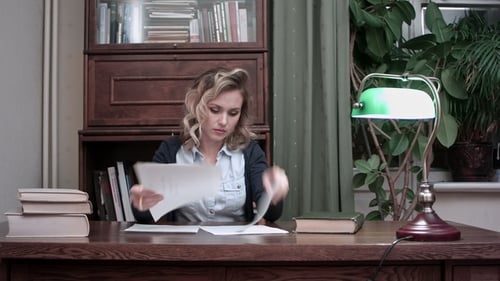 Young Woman Going Through Papers and Making Notes