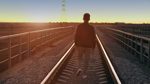 a Man Walking Away at Sunset